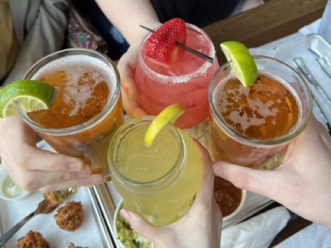 Four friends clink glasses at Agave & Rye Centerville