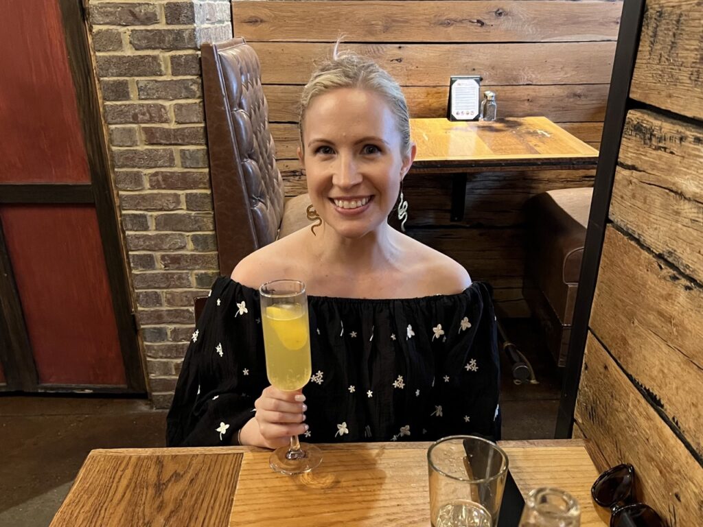 Me wearing a top from Shoppe Smitten while sipping a mimosa in Lexington, KY